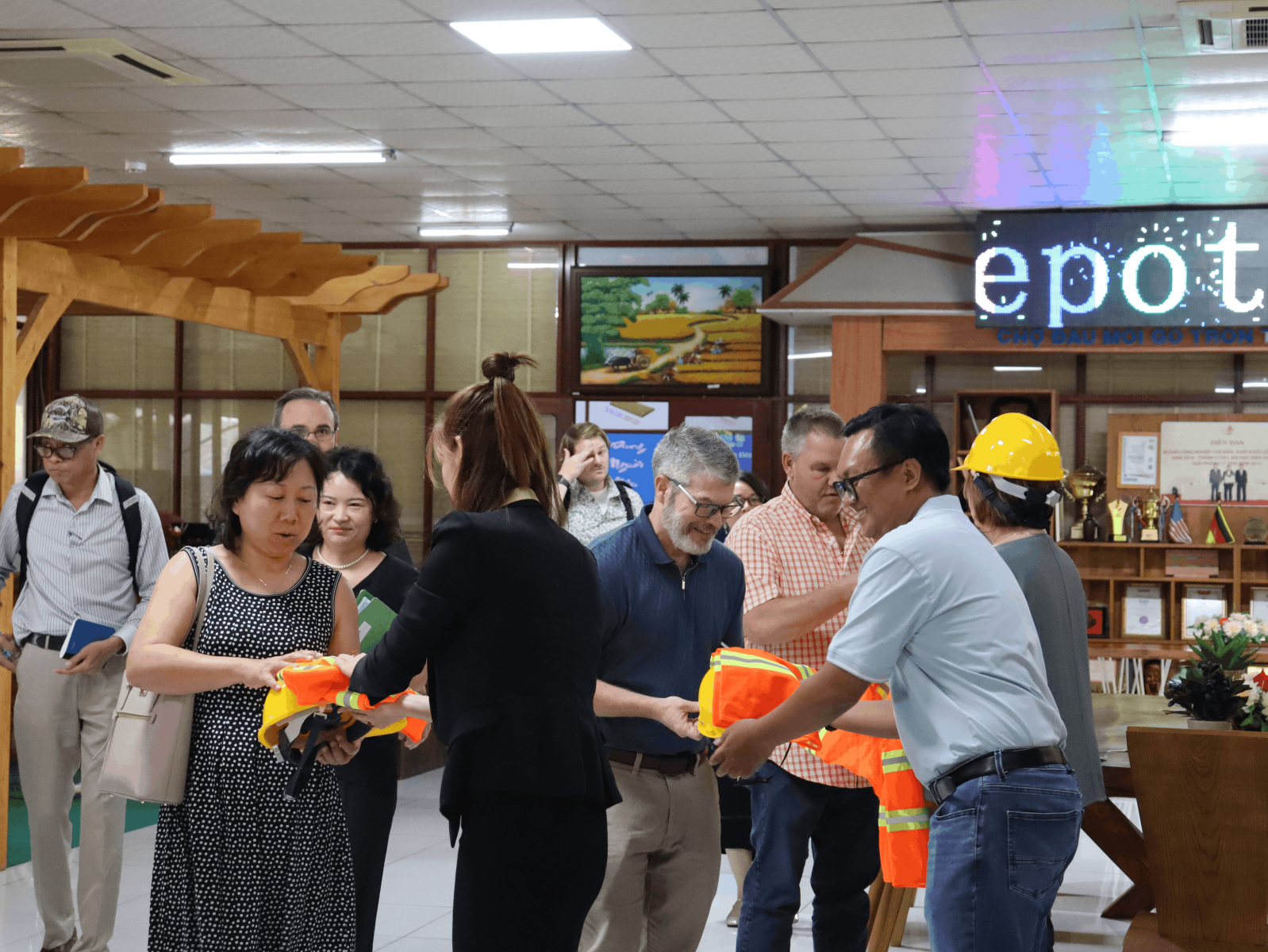 Đoàn khách nhận đồ bảo hộ để đi tham quan nhà xưởng 